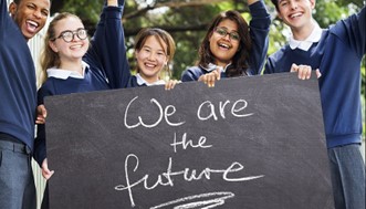 Happy children waving with a sign saying We are the future